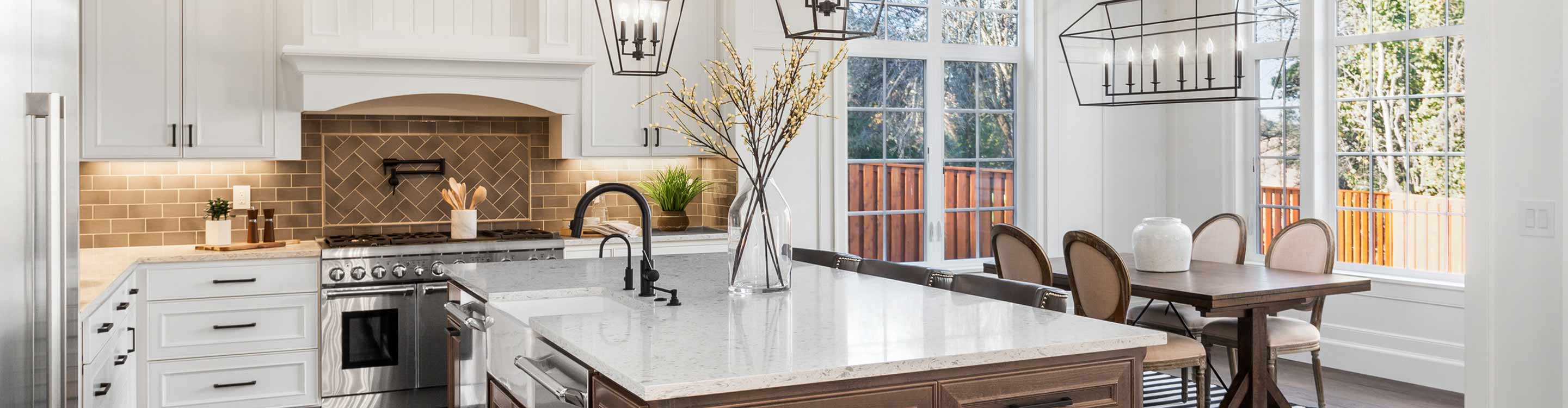 Kitchen with large island, white cabinetry and tile backsplash